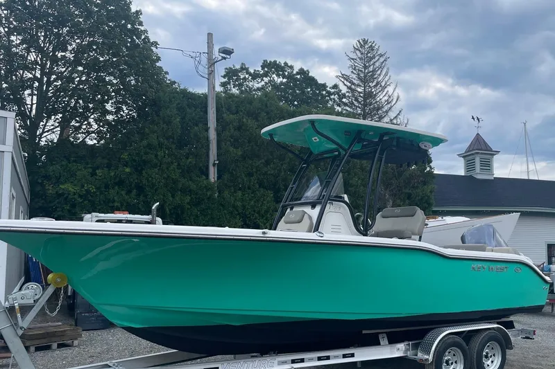 The Image of 2024 Key West 239 FS boat on trailer, vibrant teal color, parked outdoors. - 0