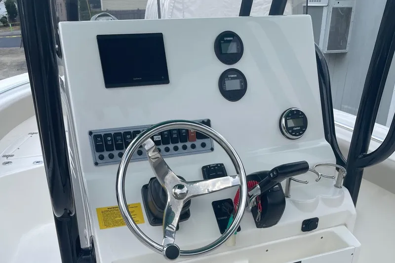 Slide: The Image of 2024 Key West 239 FS boat dashboard with steering wheel and electronic controls. - 2