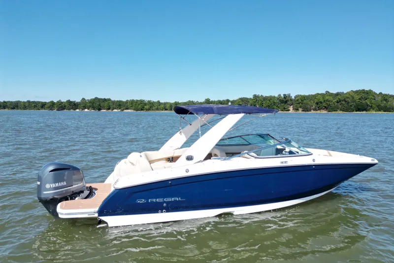 Slide: The Image of 2019 Regal 26 OBX boat with Yamaha engine on a sunny lake. - 0