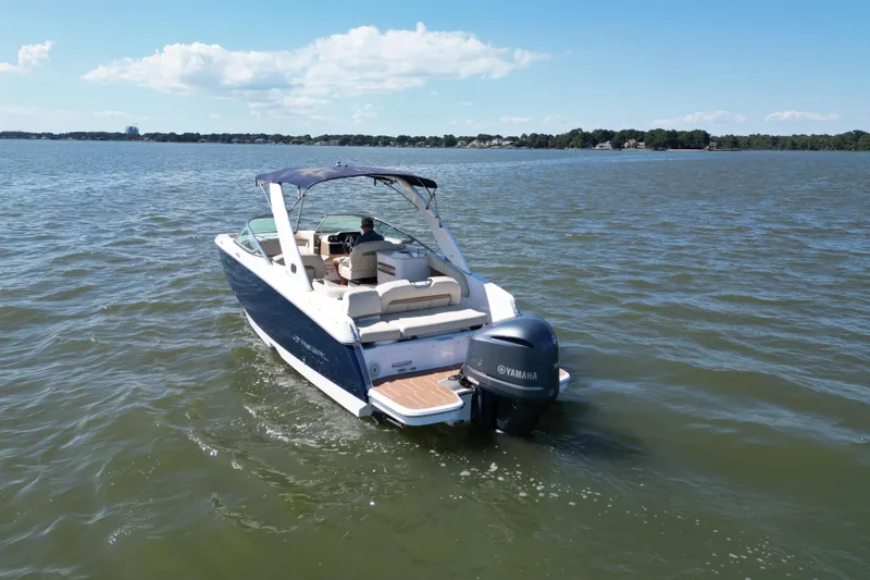 Slide: The Image of 2019 Regal 26 OBX boat cruising on a sunny lake with Yamaha outboard motor. - 2