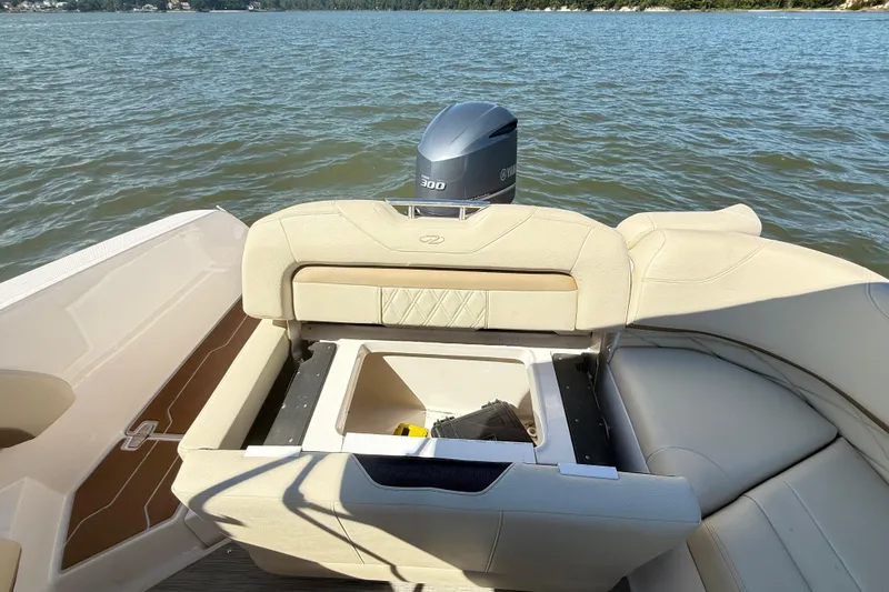Slide: The Image of 2019 Regal 26 OBX boat with open storage compartment on a calm lake. - 21