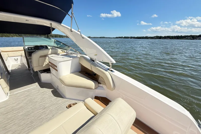 Slide: The Image of 2019 Regal 26 OBX boat interior with seating, on a sunny lake. - 25