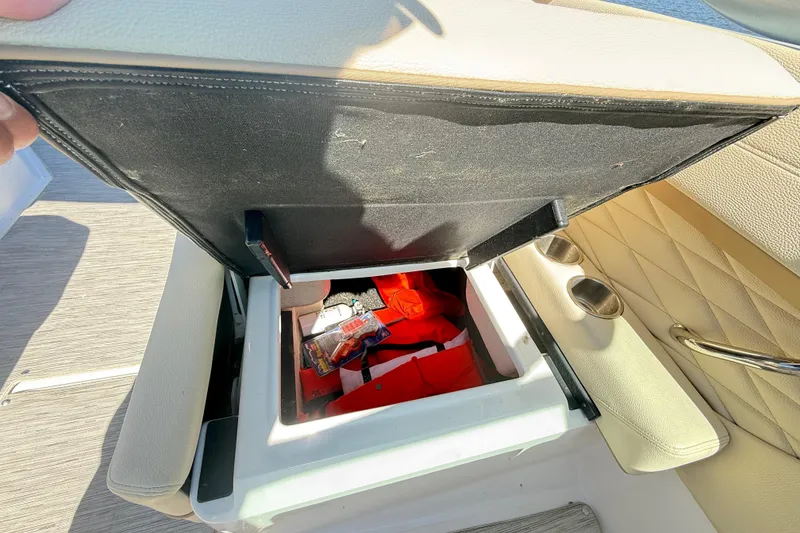 Slide: The Image of Open storage compartment on 2019 Regal 26 OBX boat with various items inside. - 27