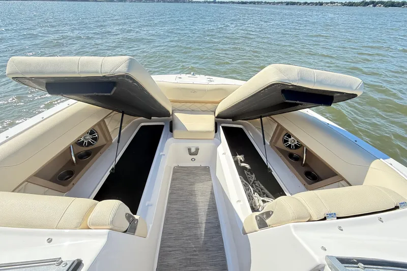 Slide: The Image of 2019 Regal 26 OBX boat interior with open storage compartments on a lake. - 28