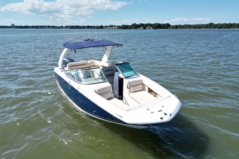 Slide: The Image of 2019 Regal 26 OBX boat on a sunny lake with blue canopy. - 3