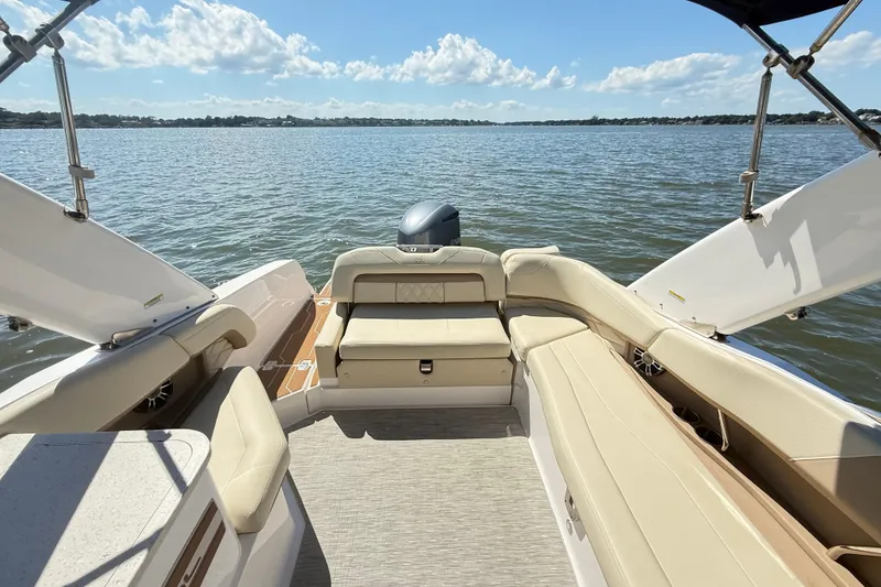 Slide: The Image of 2019 Regal 26 OBX boat interior with beige seating, overlooking calm waters and blue sky. - 6