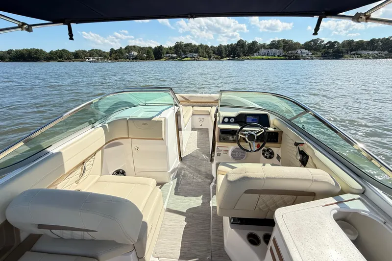 Slide: The Image of 2019 Regal 26 OBX boat interior with steering wheel, seating, and water view. - 7