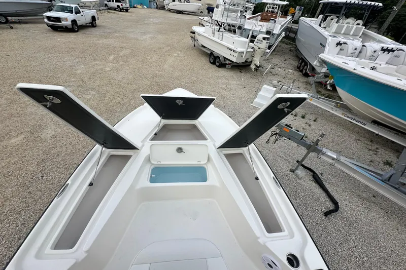 Slide: The Image of 2026 Key West 210 Bay Reef boat with open storage compartments in a marina setting. - 16