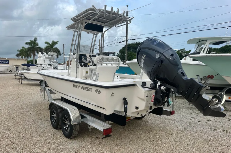 Slide: The Image of 2026 Key West 210 Bay Reef boat with Yamaha engine on trailer, parked outdoors. - 3