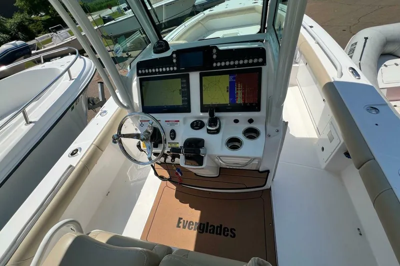 Slide: The Image of 2019 Everglades 273 Center Console boat cockpit with dual navigation screens and steering wheel. - 11