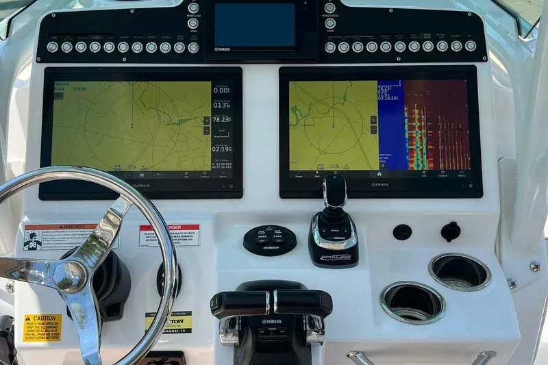 Slide: The Image of Control panel of 2019 Everglades 273 Center Console boat with navigation screens and steering wheel. - 12
