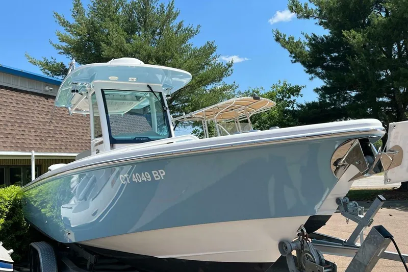 Slide: The Image of 2019 Everglades 273 Center Console boat on trailer, parked outdoors under clear sky. - 27