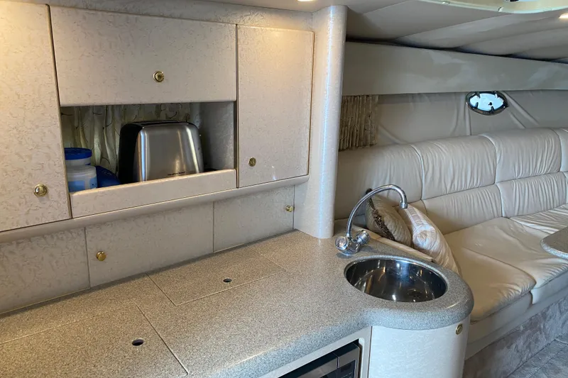 Slide: The Image of 1999 Formula 400 Super Sport yacht interior with kitchenette, sink, and seating area. - 17