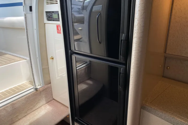 Slide: The Image of Interior of a 1999 Formula 400 Super Sport boat, featuring a compact kitchenette area. - 19