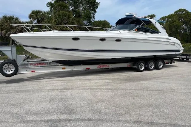 Slide: The Image of 1999 Formula 400 Super Sport boat on trailer, parked outdoors with trees in background. - 31