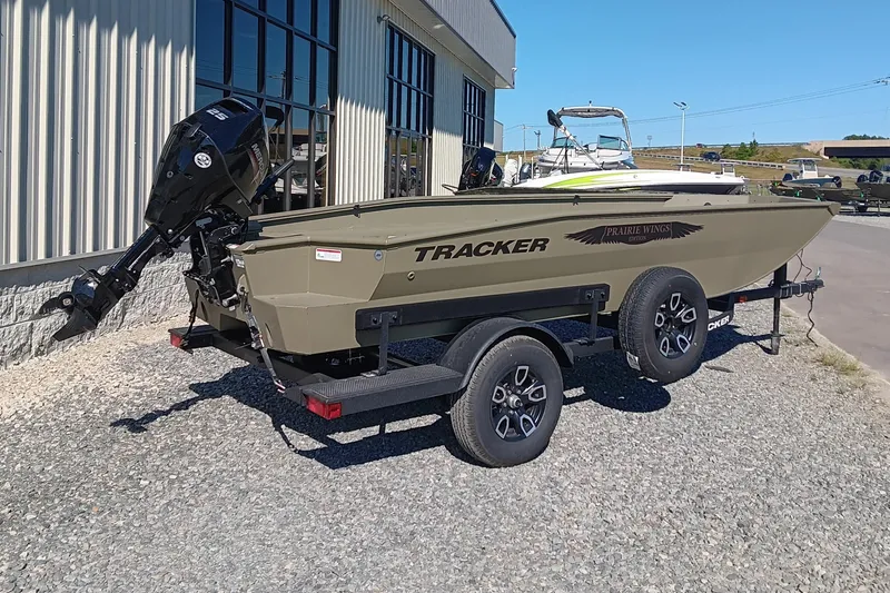 The Image of 2026 Tracker Grizzly 1650 T Prairie Wings Edition boat on trailer, parked outdoors. - 1