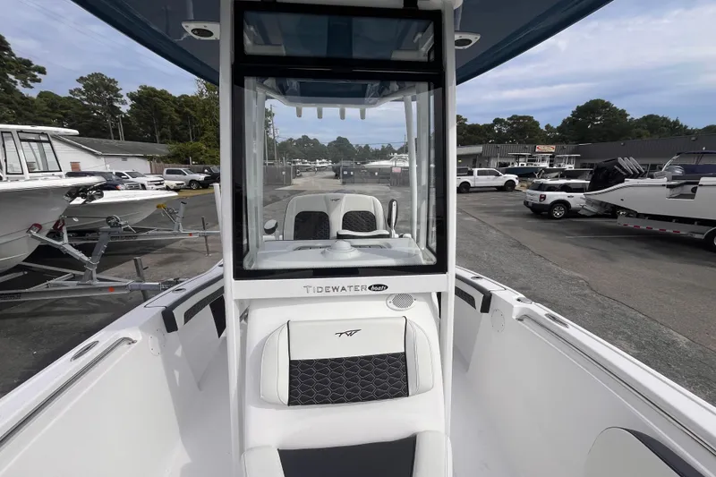 Slide: The Image of 2026 Tidewater 210 LXF boat, sleek design, parked in a marina with other boats. - 11