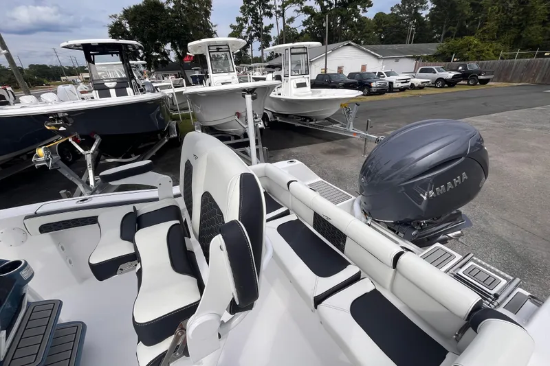 Slide: The Image of 2026 Tidewater 210 LXF boat with Yamaha engine, parked among other boats. - 14