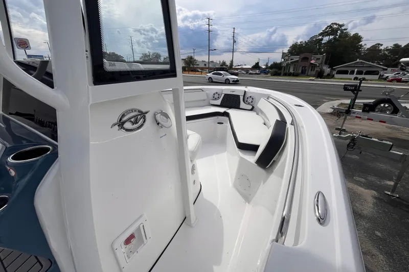 Slide: The Image of 2026 Tidewater 210 LXF boat interior with seating and speakers, parked near a road. - 9