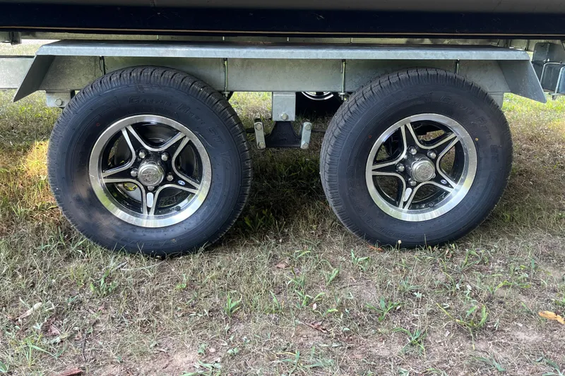 Slide: The Image of Trailer wheels of 2025 Bentley Pontoons 220/223 Elite Admiral on grass. - 12