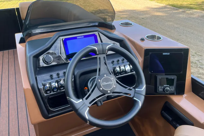 Slide: The Image of 2025 Bentley Pontoons 220/223 Elite Admiral dashboard with steering wheel and Simrad displays. - 19