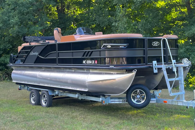 Slide: The Image of 2025 Bentley Pontoons 220/223 Elite Admiral on trailer, parked in grassy area. - 2