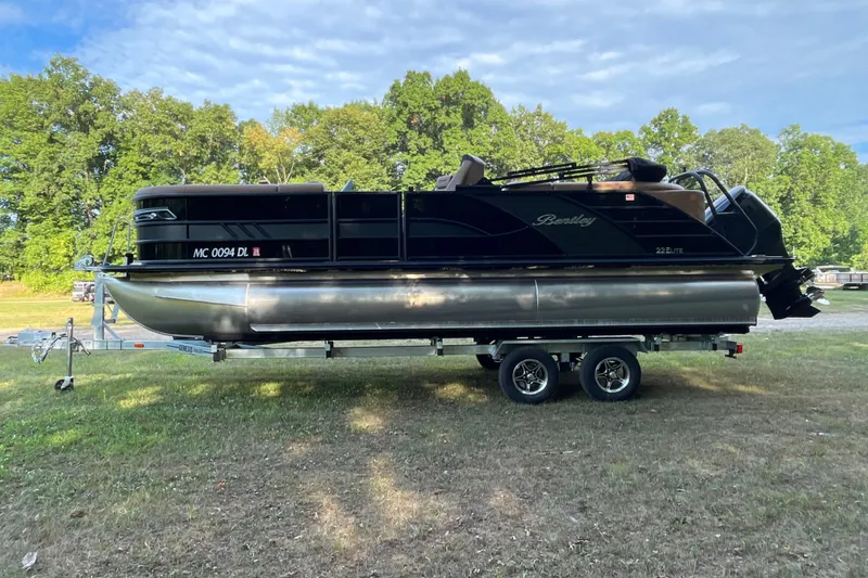 Slide: The Image of 2025 Bentley Pontoons 220/223 Elite Admiral on trailer, parked on grassy area. - 5