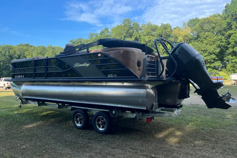 Slide: The Image of 2025 Bentley Pontoons 220/223 Elite Admiral on trailer, parked outdoors. - 6