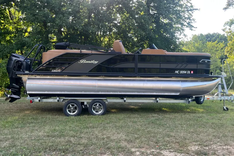 Slide: The Image of 2025 Bentley Pontoons 220/223 Elite Admiral on trailer, parked on grass. - 9