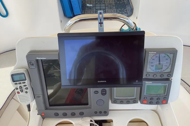 Slide: The Image of Cockpit navigation instruments on a 2001 Hunter 380 sailboat, featuring Garmin and Raymarine displays. - 19