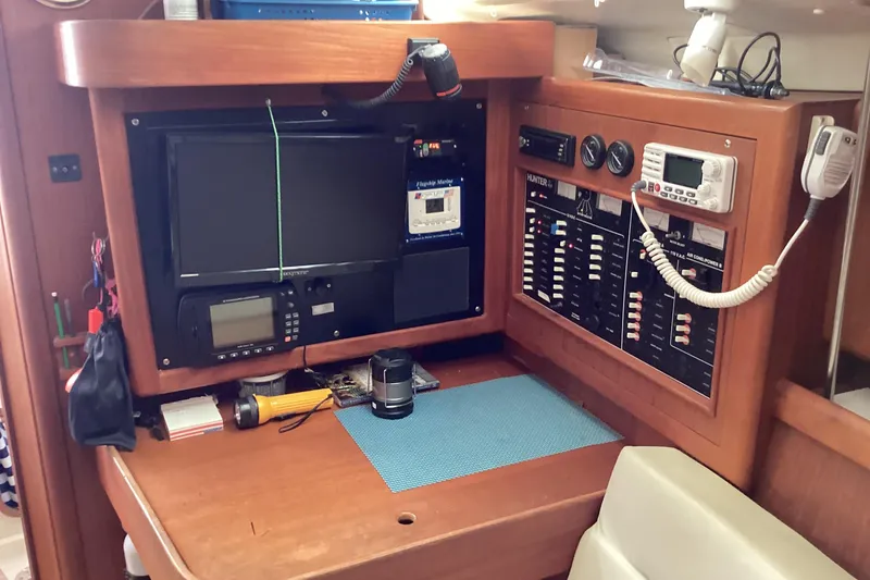 Slide: The Image of Navigation station of a 2001 Hunter 380 sailboat with control panels and equipment. - 23