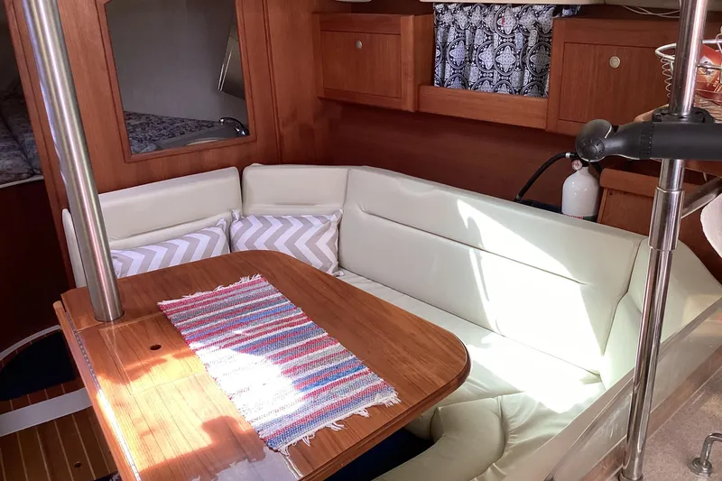 Slide: The Image of Cozy interior of 2001 Hunter 380 sailboat with cushioned seating and wooden table. - 31
