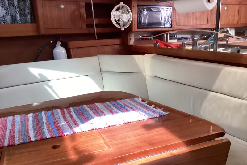 Slide: The Image of Cozy interior of 2001 Hunter 380 sailboat with wooden table and cushioned seating. - 32