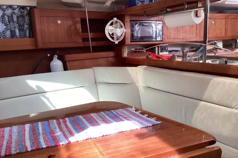 Slide: The Image of Cozy interior of 2001 Hunter 380 sailboat with wooden cabinetry and white seating. - 33
