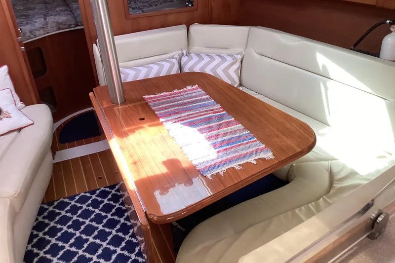 Slide: The Image of Cozy interior of 2001 Hunter 380 sailboat with wooden table and cushioned seating. - 34