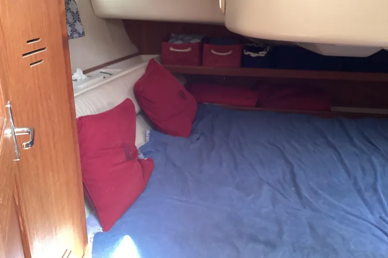 Slide: The Image of Cozy cabin interior of 2001 Hunter 380 sailboat with red cushions and blue bedding. - 39