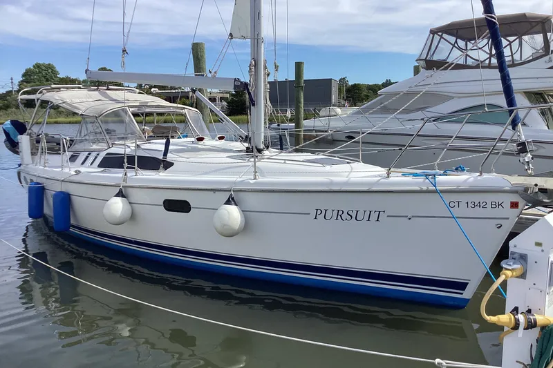 Slide: The Image of 2001 Hunter 380 sailboat named "Pursuit" docked in a marina. - 4