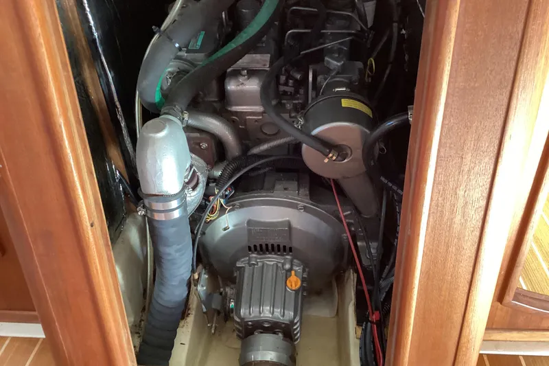 Slide: The Image of Engine compartment of a 2001 Hunter 380 sailboat, showcasing mechanical components and wiring. - 42