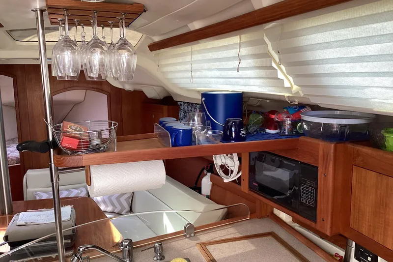 Slide: The Image of Interior of 2001 Hunter 380 sailboat kitchen with wooden cabinetry and glassware. - 45