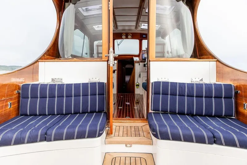 Slide: The Image of Interior view of 2002 Hinckley Talaria 44 yacht with striped seating and wooden finishes. - 17