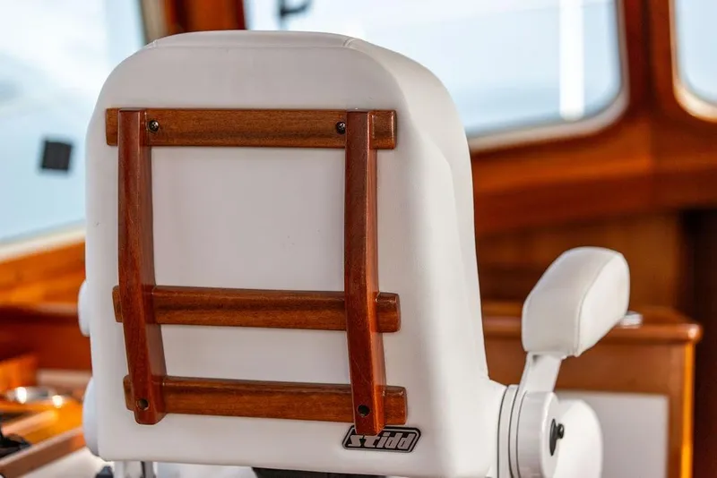 Slide: The Image of Captain's chair on 2002 Hinckley Talaria 44 yacht, featuring wooden accents and white upholstery. - 20