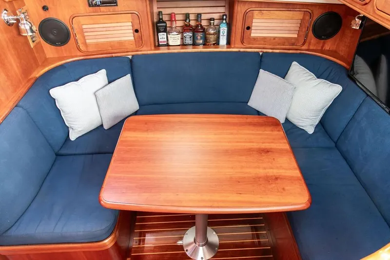Slide: The Image of Cozy interior of 2002 Hinckley Talaria 44 yacht with blue seating and wooden table. - 27