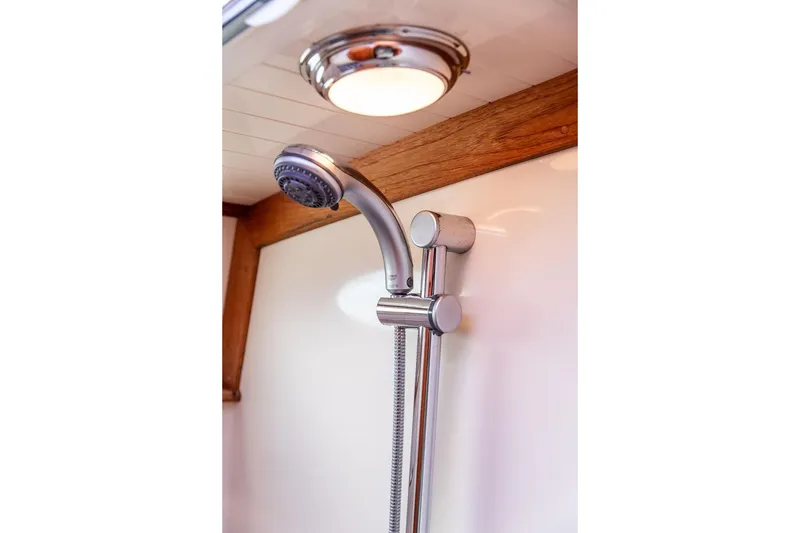 Slide: The Image of Shower fixture in 2002 Hinckley Talaria 44 yacht bathroom, featuring chrome finish and wooden accents. - 34