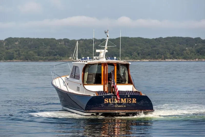 Slide: The Image of 2002 Hinckley Talaria 44 yacht named "Summer" cruising on calm waters. - 7