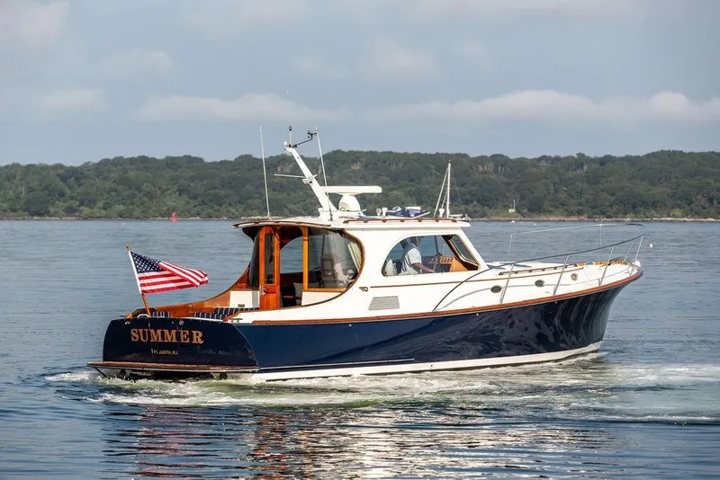 Slide: The Image of 2002 Hinckley Talaria 44 yacht cruising on calm waters with American flag. - 8