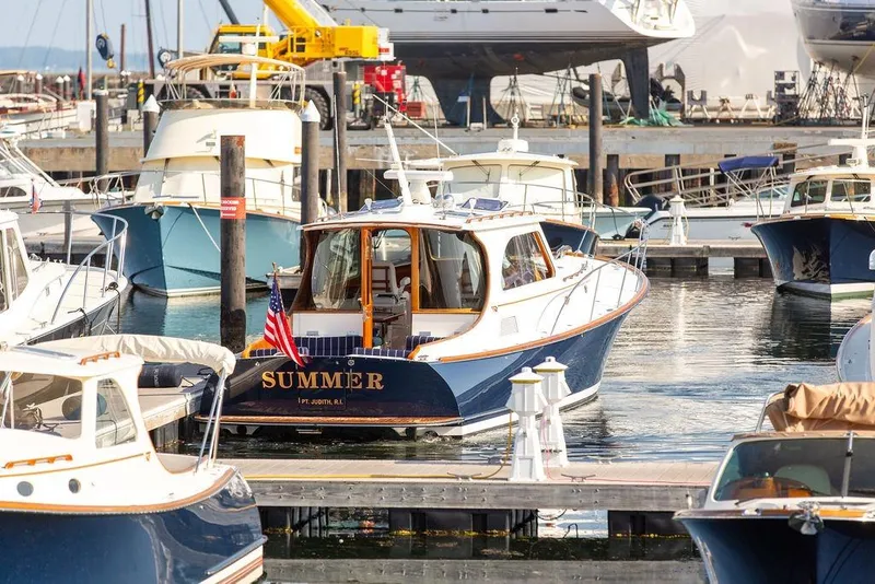 Slide: The Image of Hinckley Talaria 44 yacht from 2002 docked in a marina, surrounded by other boats. - 10