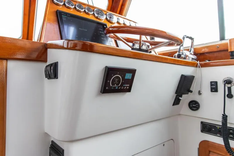 Slide: The Image of Helm of 2002 Hinckley Talaria 44 yacht with wooden accents and modern controls. - 25