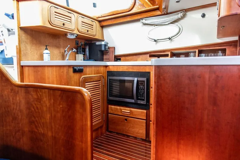Slide: The Image of Hinckley Talaria 44 yacht kitchen interior, featuring wood cabinetry and modern appliances, 2002 model. - 28