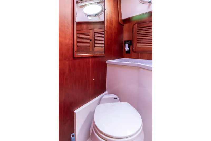 Slide: The Image of Hinckley Talaria 44 (2002) yacht bathroom with wooden cabinetry and modern fixtures. - 33
