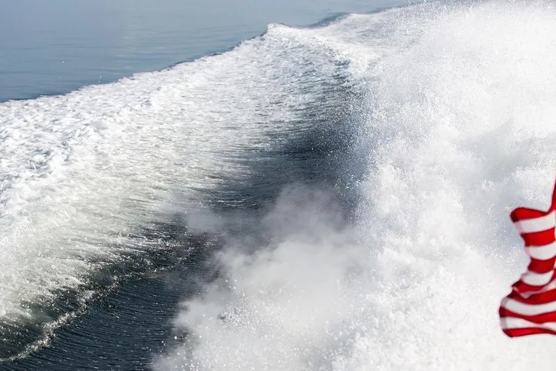 Slide: The Image of Wake of a 2002 Hinckley Talaria 44 boat with a waving flag. - 37